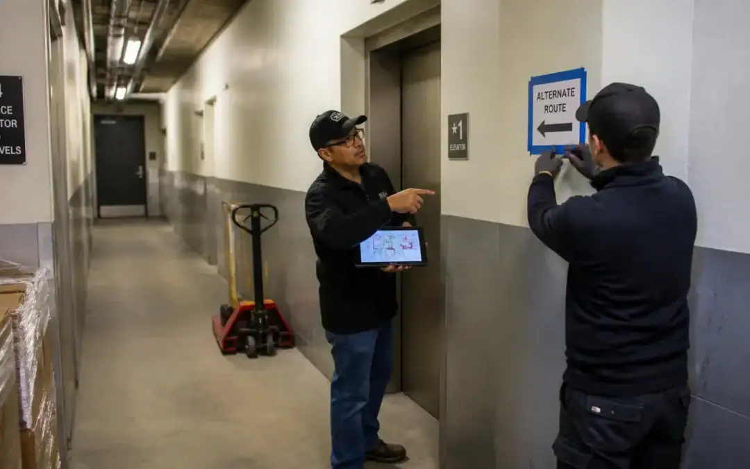 Mover reviewing a delivery checklist in a building service corridor